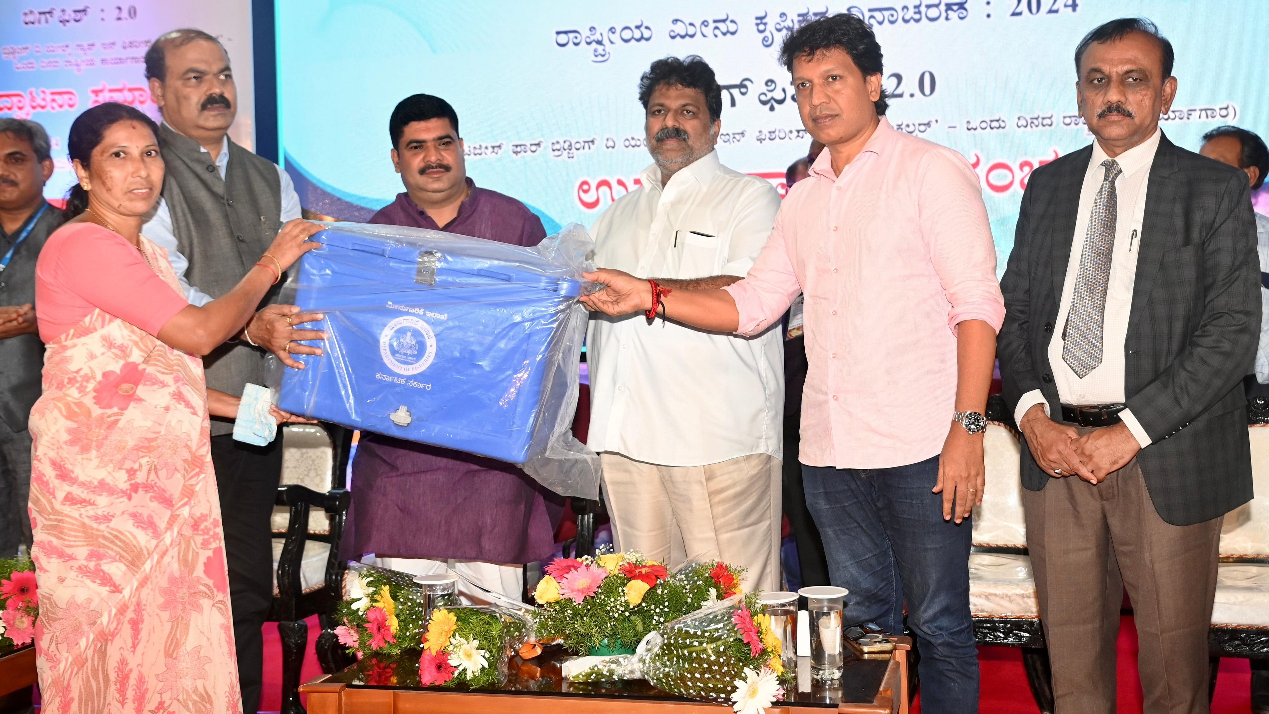 <div class="paragraphs"><p>Minister of fisheries, ports and inland water transport Mankal S Vaidya hands over ice box to a selected beneficiary from the fisheries department, at national fish farmers day held at Fisheries College in Mangaluru on Saturday.</p></div>